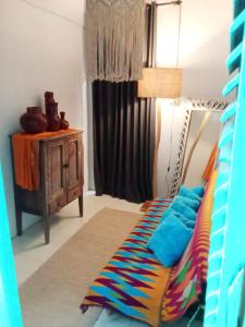 a room with a bed with a colorful blanket at Local House Grenceng 2 in Denpasar