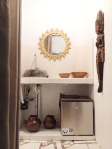 un bagno con lavandino e specchio su una mensola di Local House Grenceng 2 a Denpasar