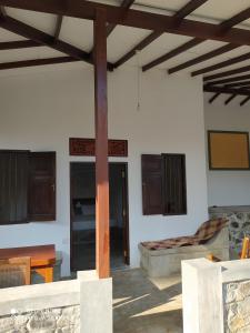 Cette chambre dispose d'un lit et d'un poteau en bois. dans l'établissement Priyanka Villa, à Bentota