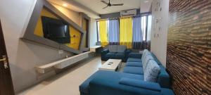 RK 2 and 3 bedroom penthouse في باناجي: غرفة معيشة مع أرائك زرقاء وتلفزيون
