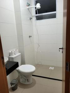 y baño blanco con aseo y ducha. en Apartamento em Ponta de Campina a 600m da praia, en Cabedelo