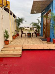 a wooden deck with two chairs and a table at Prakash Homestay in Hampi +11 photos