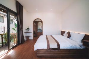 a bedroom with a large bed with white sheets at Nori Home Đà Lạt in Da Lat