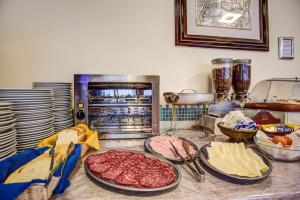a kitchen counter with meat and cheese and an oven at Hotel Tiziana in Rimini