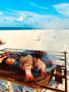 - un grill avec de la viande sur la plage dans l'établissement Balma Beach Inn, à Faafu