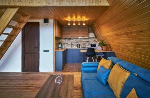 ein Wohnzimmer mit einem blauen Sofa und einer Küche in der Unterkunft Ja ge • ჟა ღე in Tsalka