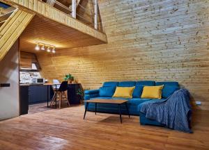 ein blaues Sofa in einem Zimmer mit Ziegelwand in der Unterkunft Ja ge • ჟა ღე in Tsalka