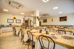 a banquet hall with tables and chairs in a room at Hotel Tiziana in Rimini
