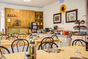 a restaurant with tables and chairs and a counter at Hotel Tiziana in Rimini