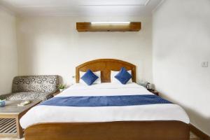 een slaapkamer met een groot bed en een bank bij Hotel The Eden Park in Noida