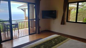 a room with a view of a balcony with a television at Infinity Heights Resort in Siquijor