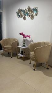 a waiting room with two chairs and a table with flowers at JP Suites & Residences in Tayabas