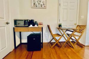 a room with a desk with a microwave and a table with chairs at Studio in the heart of Rockville in Rockville