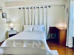 1 dormitorio con cama blanca y ventana en Studio in the heart of Rockville, en Rockville