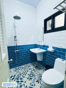 baño azul y blanco con aseo y lavabo en Lazy Time B&B, en Miaoli