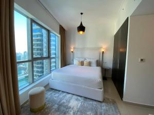 a bedroom with a white bed and a large window at Dream Inn Apartments - Bay Central in Dubai