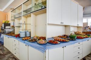 einen Tisch mit Teller mit Lebensmitteln in der Küche in der Unterkunft Hotel Tiziana in Rimini