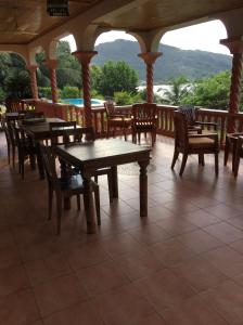 porche con mesas y sillas de madera y vistas en Bayview Villa -Sea Side Villa, en Mahe
