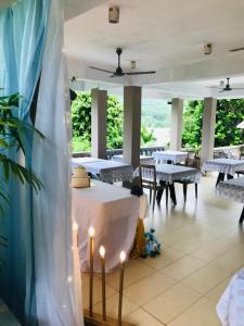a dining room with tables and chairs and lights at Bayview Villa -Sea Side Villa in Mahe