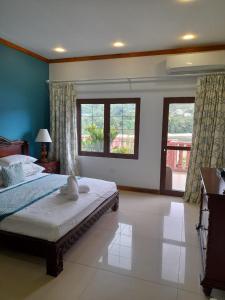 a bedroom with a large bed and two windows at Bayview Villa -Sea Side Villa in Mahe