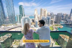 mężczyzna i kobieta stojący na szczycie wieżowca w obiekcie Wyndham Dubai Marina w Dubaju