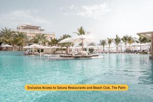 杜拜的住宿－溫德姆杜拜碼頭飯店，度假村内带椅子和遮阳伞的游泳池
