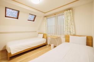 una camera da letto con due letti e una finestra di Hotaku HOTEL Akihabara a Tokyo