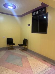 two chairs in a waiting room with aption sign on the wall at 020-22 Airbnbs in Thika