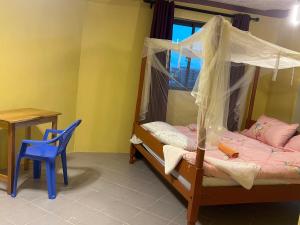 1 dormitorio con cama con dosel y silla azul en 020-22 Airbnbs, en Thika