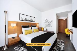 a bedroom with a large bed with yellow pillows at TRYP by Wyndham Dubai in Dubai