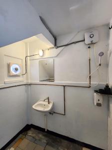 ein Bad mit einem Waschbecken und einem Spiegel in der Unterkunft Bestow Boutique Hotel in Kuala Lumpur