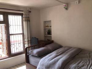 um quarto com uma cama e uma grande janela em Samriddhi HomeStay em Catmandu