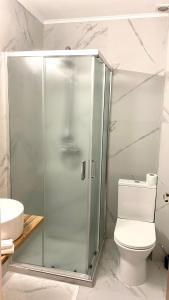 een badkamer met een glazen douche en een toilet bij Pension Delia Gardens in Timişoara