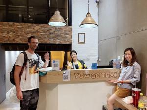 a group of people standing at a food counter at YOWGO THAI guest House in Bangkok