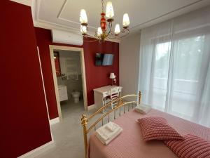 a bedroom with a bed and a red wall at Nonna Mina B&B in Rapagnano