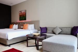 ein Hotelzimmer mit 2 Betten und einem Sofa in der Unterkunft Qliq Damansara Hotel in Petaling Jaya
