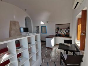 a kitchen and dining room with a counter and a table at Il Nido Del Falco - Art house with terrace and sea view in Furore