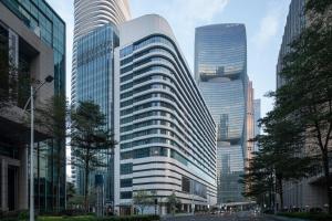 a tall building with many windows in a city at MaxX by Steigenberger Guangzhou Zhujiang New Town - Free Shuttle bus to Canton Fair Complex during Canton Fair Period in Guangzhou