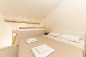 a white bedroom with two white towels on a bed at Mystery Suites and Apartments in Nei Poroi