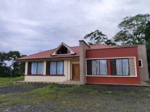 mały dom z czerwonym dachem w obiekcie La Perla House w mieście Sucúa