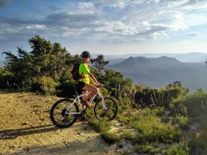 a woman riding a bike on a mountain trail at Mountain Culture Farm Stay - pet friendly in Kanimbla