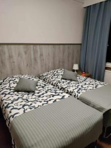 two beds sitting next to each other in a bedroom at Hotel Ackas in Toijala