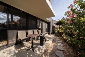 un patio con sillas y una mesa en un edificio en BEPPU HOSTEL U&T, en Beppu