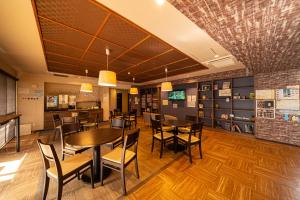 a restaurant with tables and chairs in a room at BEPPU HOSTEL U&T in Beppu