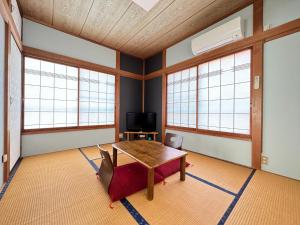 Calmbase Nishi Izu - Vacation STAY 30929v في Toda: غرفة مع طاولة وكراسي ونوافذ