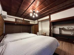 una camera da letto con un grande letto bianco e un soffitto in legno di CalmbaseRIVER - Vacation STAY 22009v a Numazu