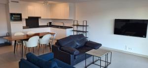 een woonkamer met een bank en een tafel en een keuken bij North beach in Oostende