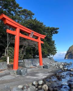 una puerta Torii naranja en una playa cerca del agua en CalmbaseRIVER - Vacation STAY 22009v en Numazu