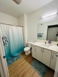 a bathroom with a toilet and a sink and a mirror at The Plaisir - Pool & Spa in Santa Clarita