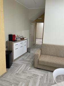 Una sala de estar con un sofá y una cocina. en SIKELIA LUXURY ROOMS, en Agrigento
